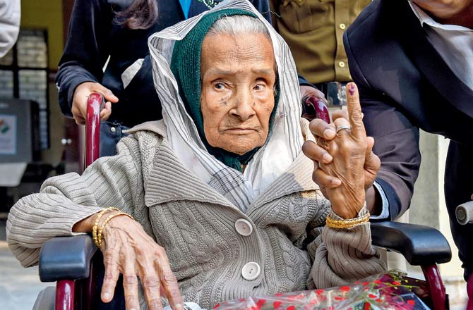 111-year-old Kalitara Mandal shows her finger marked with indelible ink