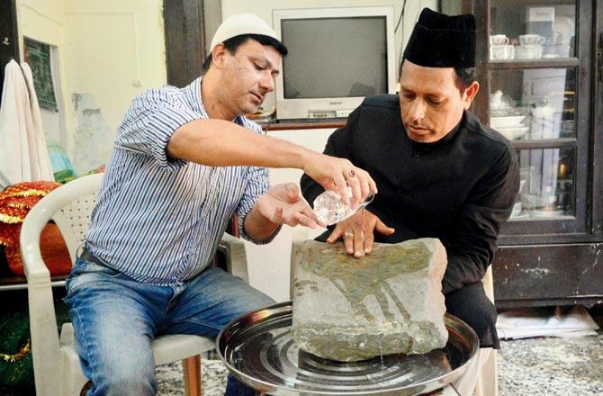 Wadala: Kazim Ahmedji and Shakeb Ahmedji washing a stone at the Shaykh Misri Dargah believed to be 500 years old and indicative of the era in which this saint came to Wadala. Pic/Falguni Agrawal