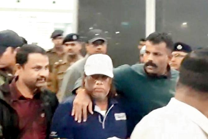 Pujari with Karnataka police at the Bengaluru airport on Monday