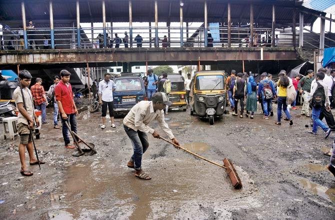 Potholes on the road outside Bandra East railway station being filled. File pic