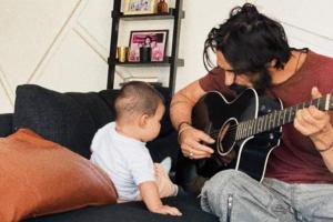 Aww! Arjun Rampal strums the guitar, while little Arik is all ears