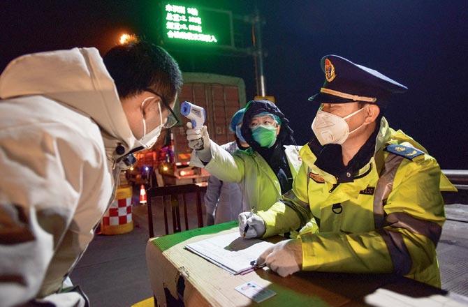 A staffer checking temperature of a driver in Zhangjiakou