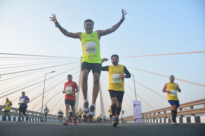 In photo: A participant jumps in joy as he crosses the Bandra Worli Sea Link during one of the races at the 17th edition of the Mumbai Marathon