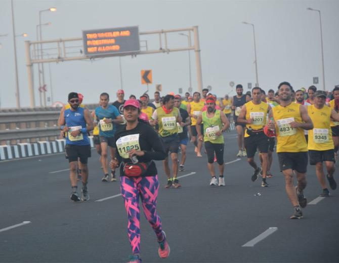 In photo: Runners participating in the 17th edition of the Mumbai Marathon are caught in a candid moment as they cross the Bandra Worli Sea Link