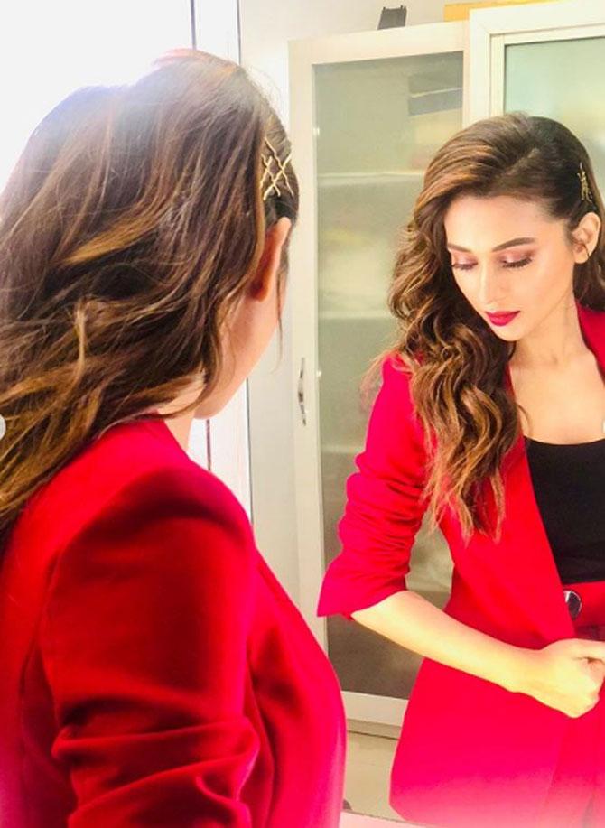 Mimi Chakraborty looked gorgeous in a bright red-coloured suit. She wore red colour lipstick and also wore eye-makeup. She struck a candid pose as she looked at herself in the mirror.