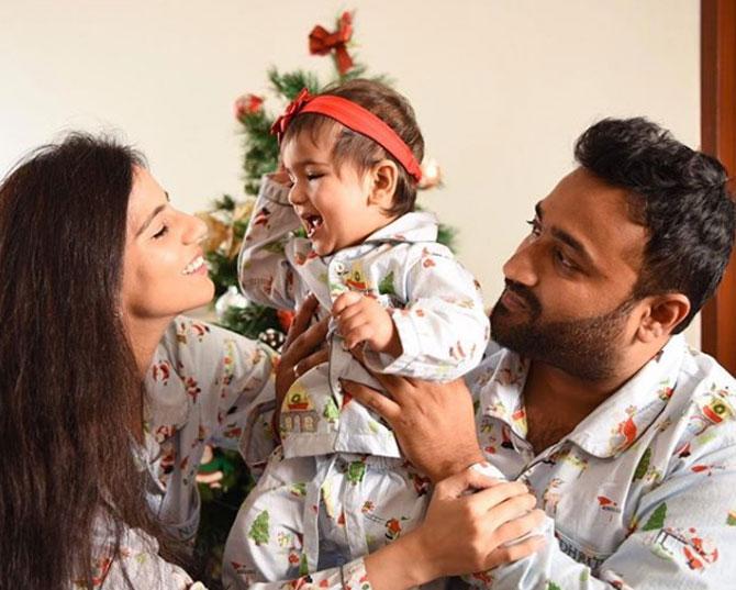 The parents made their daughter's first Christmas special by wearing and posing in the same Christmas nightsuit.