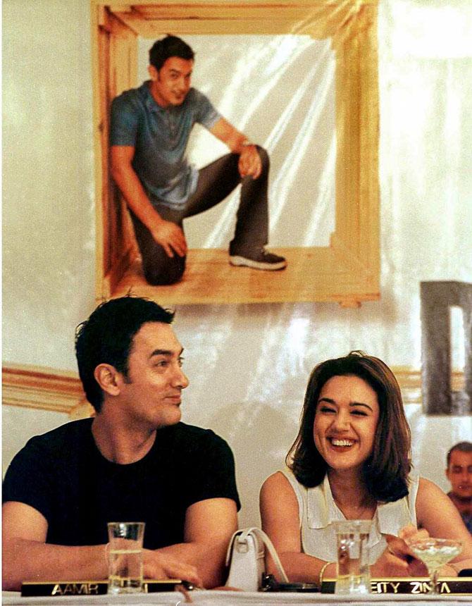 Aamir Khan and Preity Zinta speak to reporters in front of a portrait of Aamir Khan at a press conference in Calcutta on August 12, 2001. The stars were speaking about their newly released big-budget film Dil Chahta Hai.