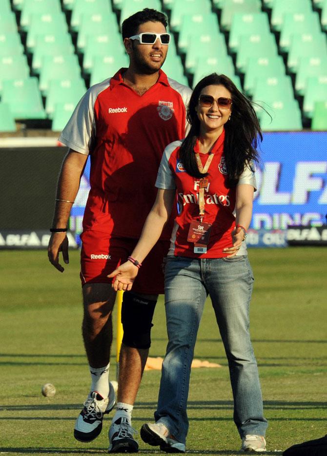 King's XI Punjab co-owner and actress Preity Zinta walks back with cricketer Yuvraj Singh after losing a toss against the Bangalore Royal Challengers for their IPL Twenty20 match at The Kingsmead Cricket Stadium in Durban on April 24, 2009. Bangalore Royal Challengers won the toss and decided to bat first against King's XI Punjab.