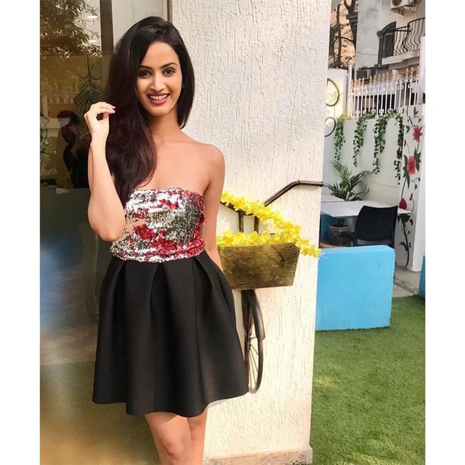 She looks ready to party in this black embellished tube dress with a simple makeup.