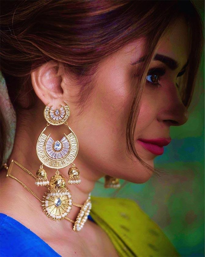 She shows off the beauty of her side profile with her layered jhumka and exquisite choker in this sari-clad avatar.