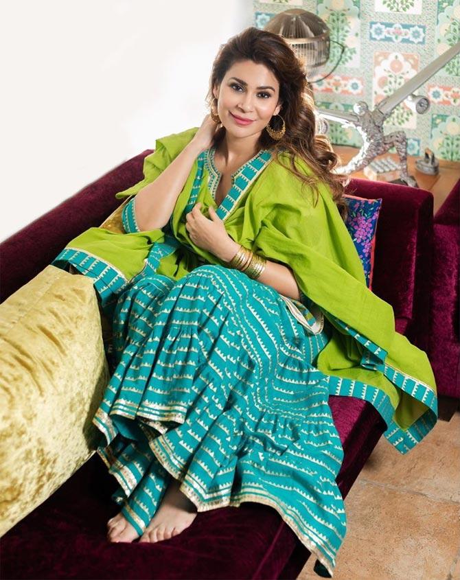She inspires for a festive family gathering in this blue and golden anarkali and green dupatta with a pair of chandbali earrings and just the right amount of matching bangles stacked in her hand.