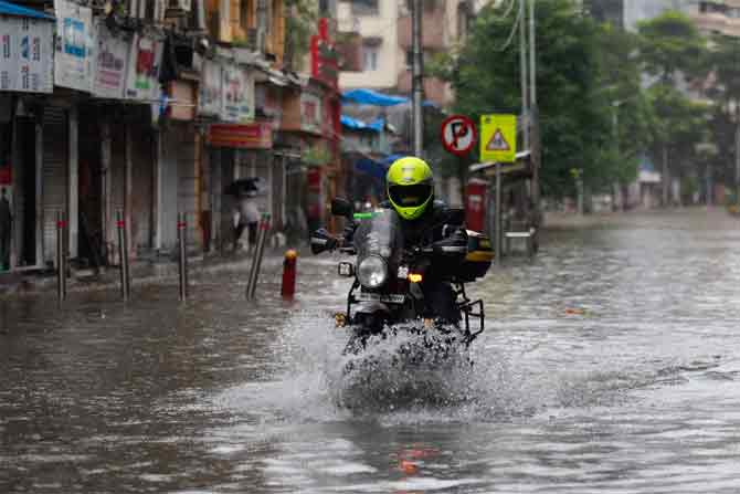 Heavy rains lashed Mumbai with instances of waterlogging reported in several areas of the city.
In picture: A deliveryman wades through a water-logged street in Parel.