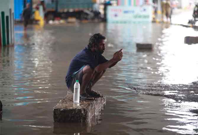 In the safety instructions issued, the civic body advised people to keep their mobile phones charged in case of emergency communications, keep torches and candles handy, store food and medicines, and refrain from venturing into waterlogged areas.
In picture: A man checks his phone as he takes evasive action from the floods at Hindmata junction in Dadar