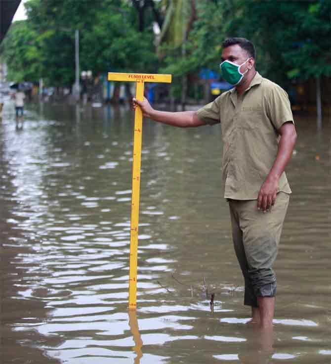 According to the Brihanmumbai Municipal Corporation (BMC), waterlogging was reported from Bhulabai Desai Road, Bindu Madhav Junction, Worli Naka, Hindmata Junction, Dhobi Ghat Cuffe Parade, Chirabazar, CP Office, and Byculla Police Station.
In picture: A BMC worker measures the water level in a waterlogged area in Parel.