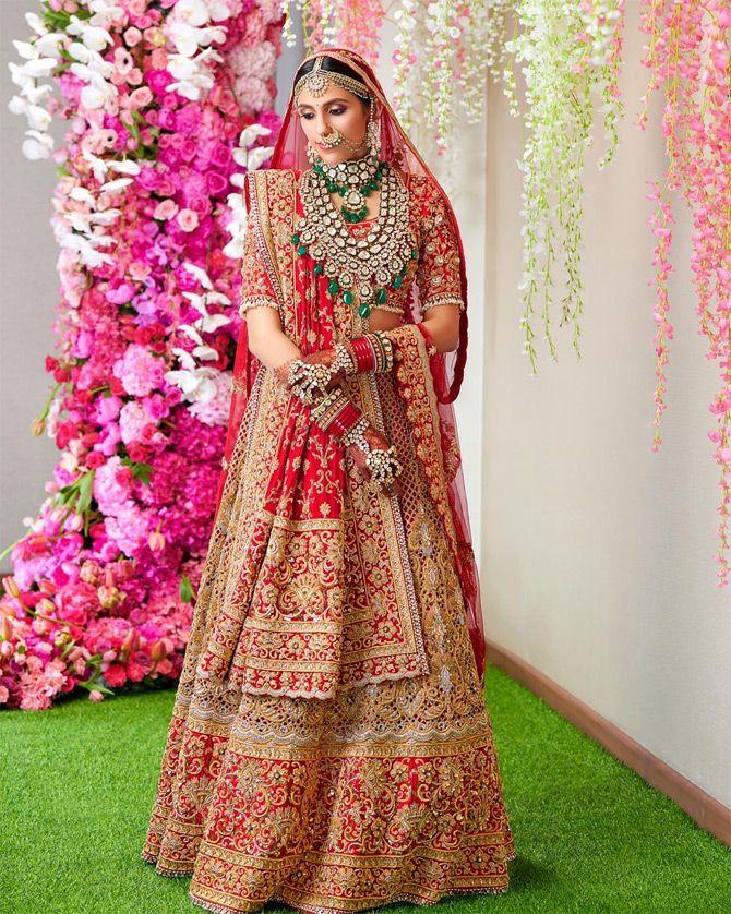In photo: Shloka Mehta looks absolutely stunning in her wedding trousseau as she stuns in a red and golden lehenga by designer Abu Jani and Sandeep Khosla. Pic/Instagram Dabboo Ratnani