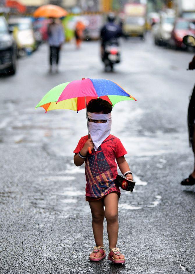 In photo: A child armed with a face mask and an umbrella was clicked at Girgaon.