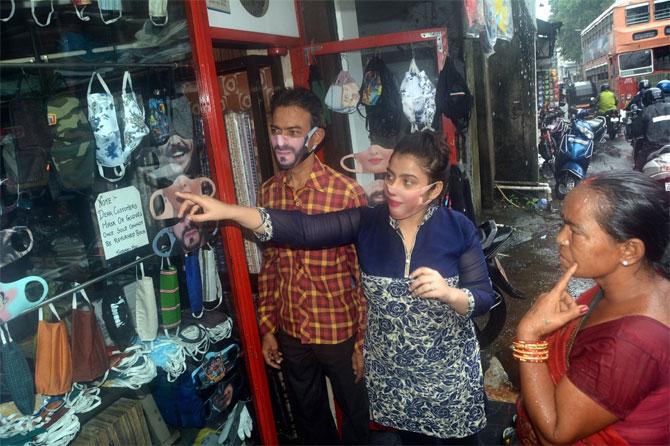 In photo: A shopkeeper shows fancy masks to customers as Mumbai opens for business.
On Saturday, Mumbai crossed the one-lakh mark in the total number of COVID-19 cases, while Maharashtra crossed three lakh positive cases.
