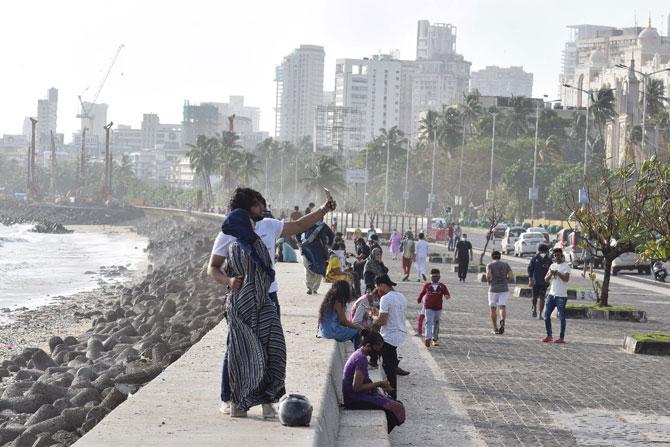 A couple poses for a selfie with the Arabian Sea in the backdrop at Marine Drive.