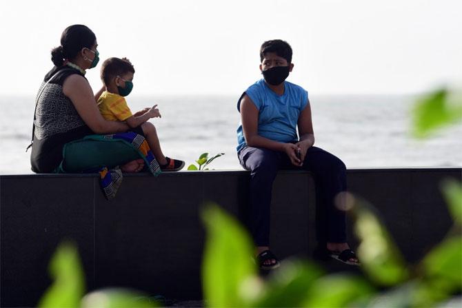 In photo: A family donning face mask enjoys the pleasant weather on Sunday evening at Worli sea face.