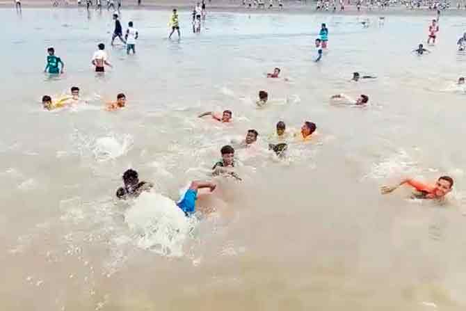 Youngsters jump into the sea to evade police action at Arnala beach