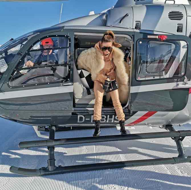 Poonawalla makes a stylish entry in a beige outfit and an oversized fur coat while alighting from a helicopter. In the caption, she wrote: 
