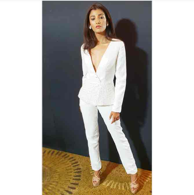 Miss India Universe 2018 Nehal Chudasama poses gracefully in a white pantsuit teamed with a pair of beige heels.  