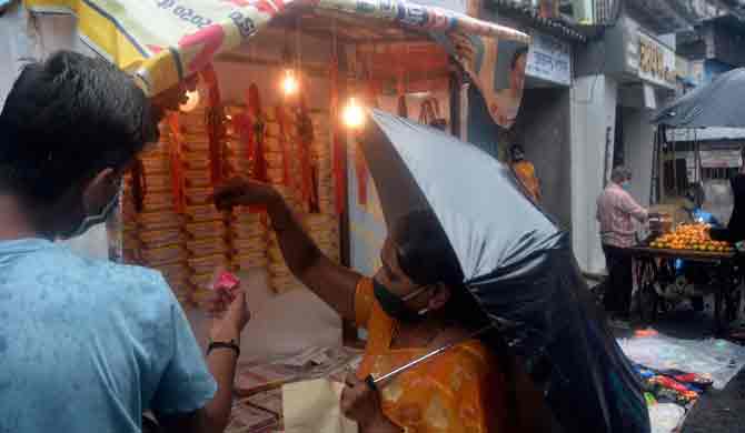 A woman takes a look at rakhis ahead of Raksha Bandhan amid the heavy rains in Kurla West.