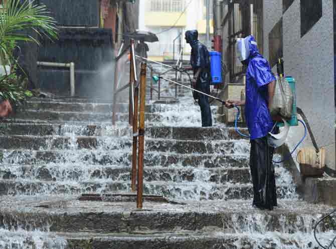 Civic workers sanitise the iron railings as water gushes through the steps of Banganga Tank at Walkeshwar.