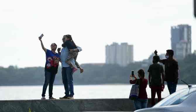 People click pictures and selfies near Marine Drive and enjoy the cloudy weather. 