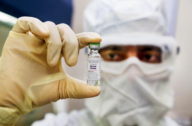 A pharmaceutical worker shows a shot of a vaccine developed by Zydus Cadila to treat COVID-19 after it received approval from the Drug Controller General of India to start phase one and two of human clinical trials, in Ahmedabad recently. Pic/AFP