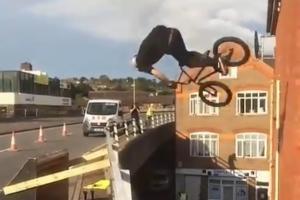 Man pulls off mid-air flip on stunt bicycle, lands on building