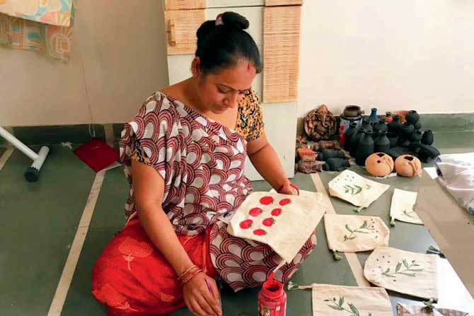 One of the women paints a bag