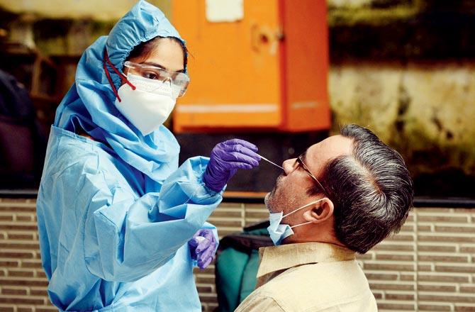 Civic health workers test Kandivli residents using rapid antigen test kits. Pic/Satej Shinde