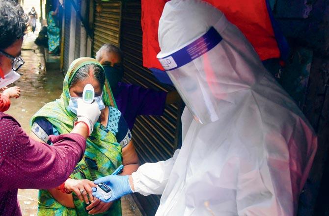 Health workers screen people for the symptoms of novel Coronavirus at Khar Danda slum
