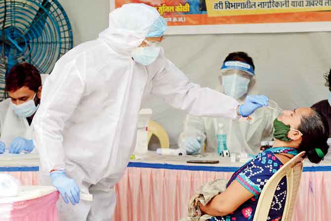 A doctor takes a swab sample of a resident of Mamledarwadi, Malad, on Thursday. PIC/SATEJ SHINDE
