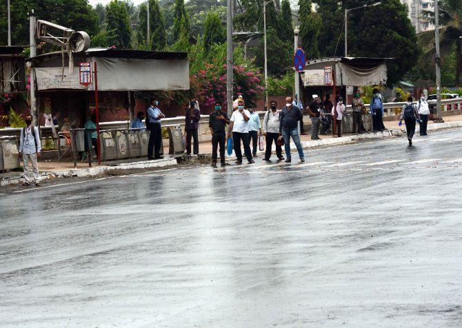 In photo: Essential service workers wait for BEST bus amid light drizzling in Mumbai