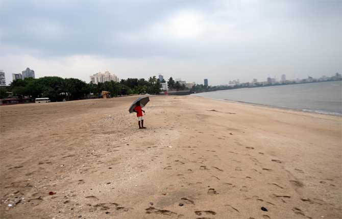 Prime Minister Narendra Modi on Tuesday assured all assistance to Maharashtra, Gujarat, Daman Diu, Dadra and Nagar Haveli regarding the cyclone situation.
In picture: A child stands at the shore while fire brigade officials conduct a response drill at  Girgaum Chowpatty