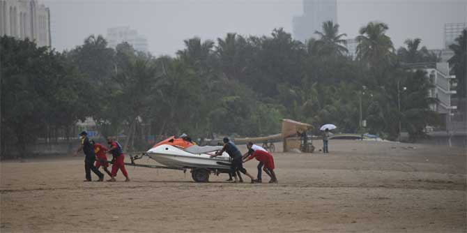 In Raigad district, which is expected to get the full force of the cyclone, 19,000 people have already been evacuated to safer areas.
In picture:  Fire brigade officials roll a speed boat away from the shore while conducting a response drill at  Girgaum Chowpatty