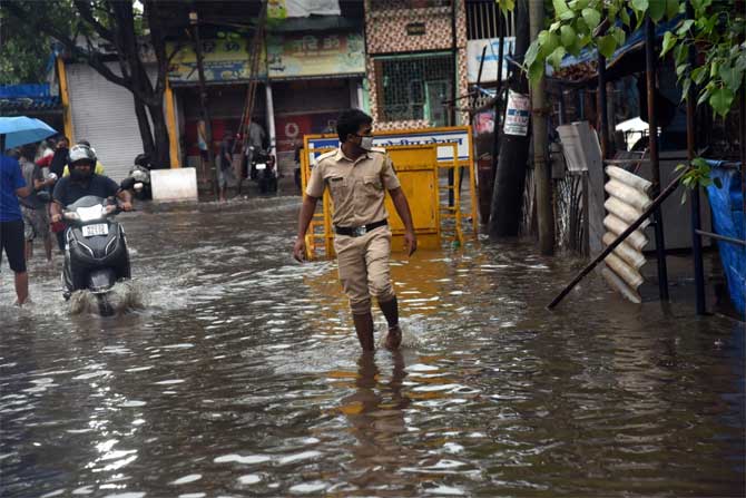 Trees and electricity poles were uprooted in many areas. Parts of Raigad district plunged into darkness and telephone connectivity too was hit in the area.
In picture: A police personnel wades through a water-logged street at Ramabai Nagar in Ghatkopar.