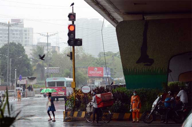 According to the statement from the Chief Minister's Office, the cyclone also felled over one lakh trees in Raigad district.
In picture: Motorists and pedestrians wait to cross the road in the Western Express Highway in Kandivli. 