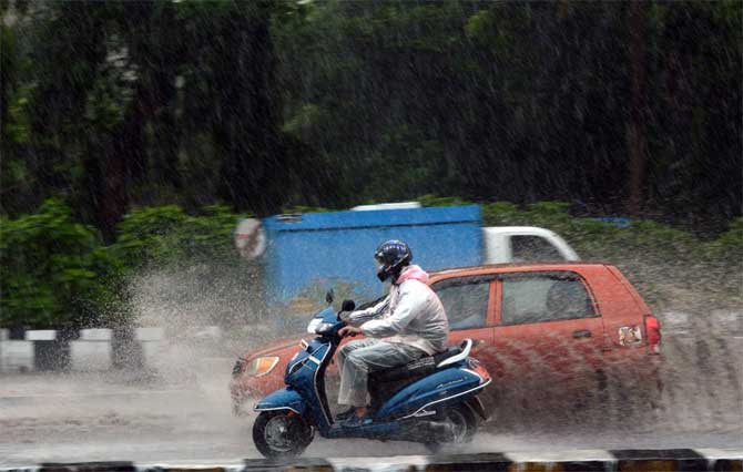 The statement also said that Shrivardhan and Murud tehsils were worst hit with all communication being paralysed.
In picture: Motorists ride on the wet roads of the Western Express Highway