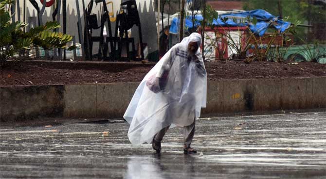 The cyclone dumped 72.5 mm of rain in Maharashtra while 78,191 people were shifted to safer places, the CMO statement said on Thursday.
In picture: A man wearing a plastic suit protects himself from the rains.