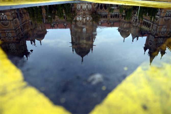 In picture: A reflection of the CSMT station on an inundated DN Road.