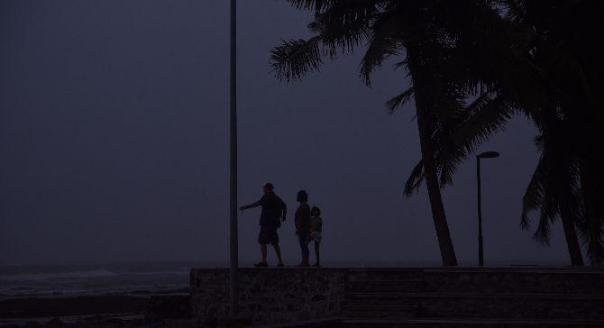 In photo: A family enjoys the weather at Carter Road in Bandra as dark clouds cover the city's skyline 