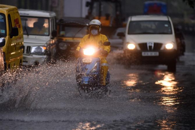 In photo: A biker rides a motorcycle through the flooded streets of Bandra after Mumbai receives heavy spells of showers.