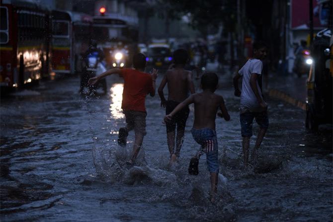 In photo: A group of children playing in the flooded streets of Bandra.