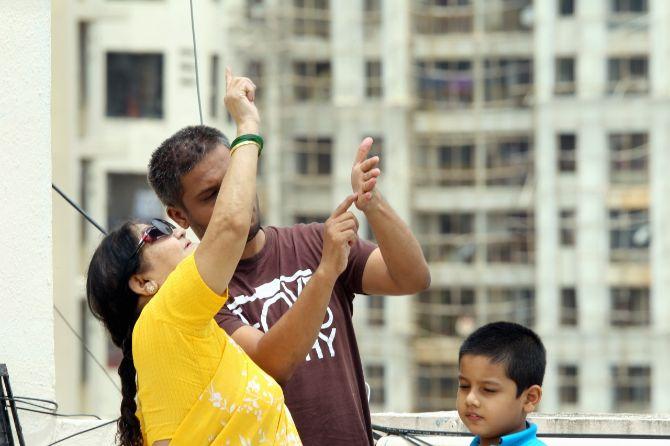 In photo: A family caught in a candid moment as they attempt to view the last solar eclipse of the decade from their residence in Powai.