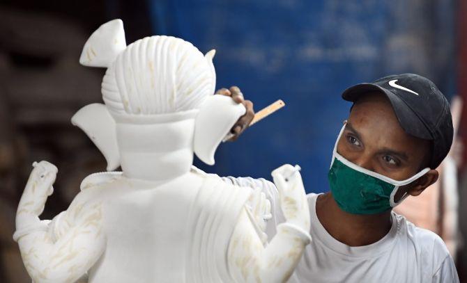 In photo: A painter gives the final touches to a Ganesh Idol at their workshop in Girgaon.