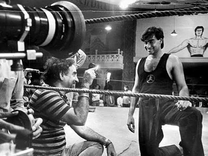 Ajay Devgn remembered his father Veeru Devgan with a priceless throwback picture, in which Ajay is seen standing inside the boxing ring and the father-son duo is having a conversation while shooting for a film. Along with the adorable monochrome throwback picture, Ajay penned down an emotional note. 