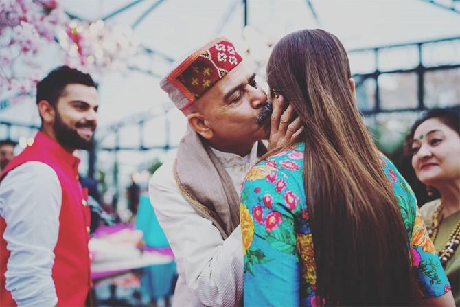 Anushka Sharma shared a heartwarming throwback picture from her Mehendi ceremony to wish her dad on the Father's Day. She also penned a note about one that she was taught by her father during college days. In the picture shared by Anushka on Instagram, her father is giving her a peck on her cheek as her mother and husband Virat Kohli look on. 